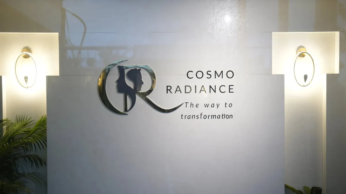 Illuminated Cosmo Radiance logo mounted on a pristine white wall in the clinic lobby