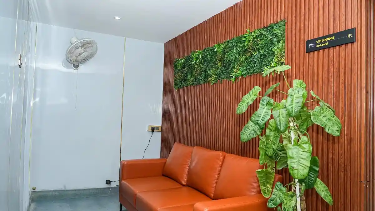 Exclusive VIP client waiting lounge with an orange plush sofa and vertical green garden